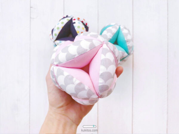 Pelota Montessori, juguete para bebé con cascabel de seguridad. Modelo "ESCAMAS GRIS Y ROSA".